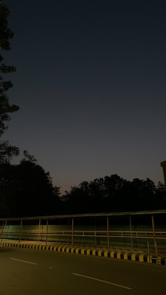 Covered walkway lit with green glow at dusk